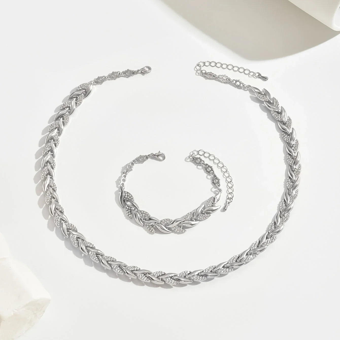 Silver fish-tail link necklace with clasp, shown with matching bracelet