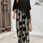 Black asymmetrical blouse with loose sleeves and wide-leg boho pants featuring black dot print