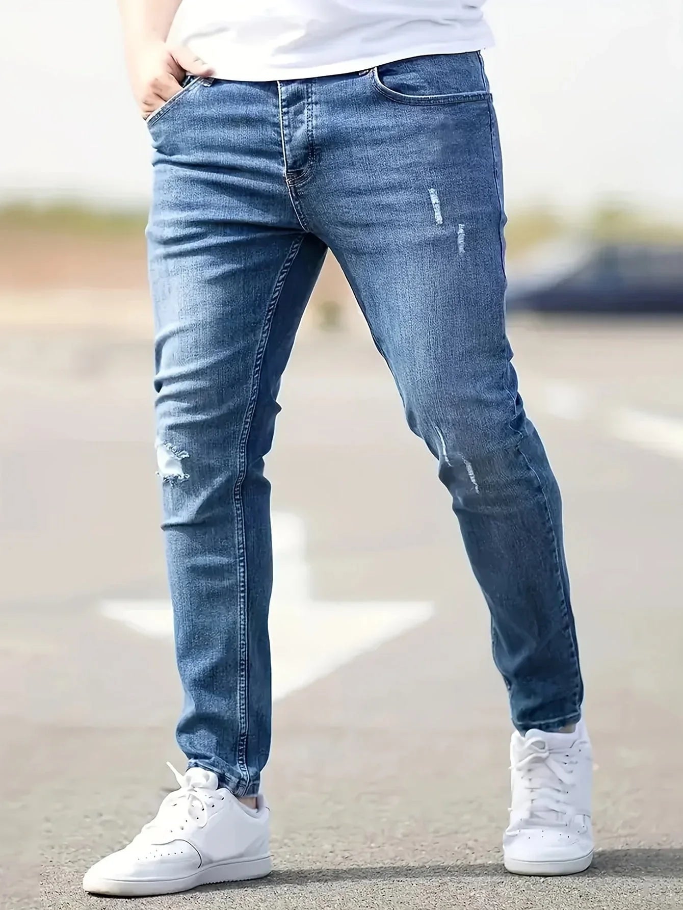 Slim-fit ripped jeans in dark blue wash, distressed knees and slim tapered legs