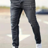 Slim-fit ripped jeans in black wash, distressed knee rips and fitted taper