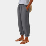 Gray linen-effect pants with elastic waist, button detail, and cuffed ankle hems
