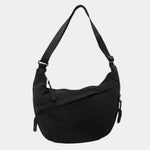 Black anti-theft crossbody bag, curved hobo shape with adjustable strap and zipper pull.