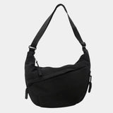 Black anti-theft crossbody bag, curved hobo shape with adjustable strap and zipper pull.