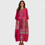 Long magenta printed dress with three-quarter sleeves and patterned border hem