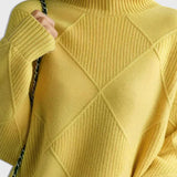 Yellow turtleneck sweater with ribbed collar and diamond quilt-like knit pattern
