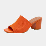 Orange knit open-toe slide sandal with chunky block heel.