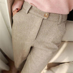 Beige herringbone trousers with front pleats and tan button detail