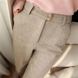 Beige herringbone trousers with front pleats and tan button detail