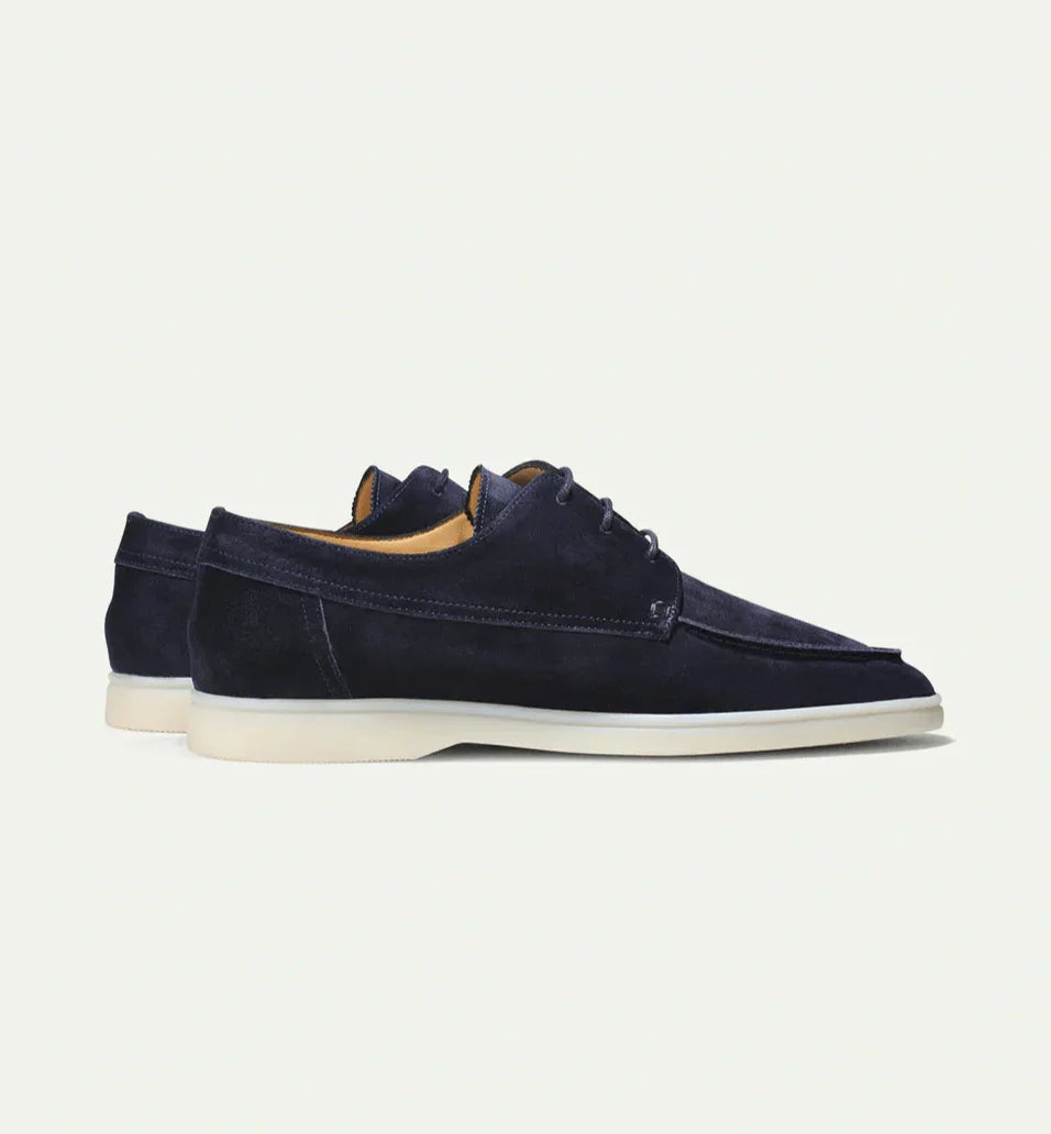 Navy blue suede lace-up loafers, side view, white rubber sole