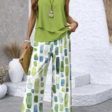Green sleeveless draped top with geometric wide-leg pants, necklace pendant
