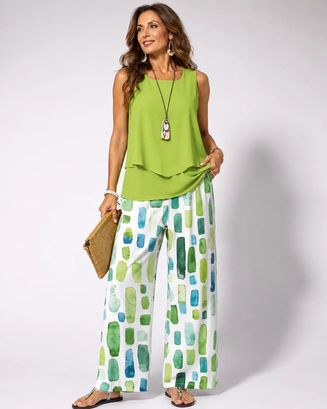 Green sleeveless top with draped hem and green geometric wide-leg pants set