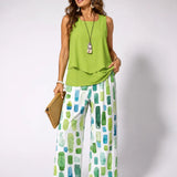 Green sleeveless top with draped hem and green geometric wide-leg pants set