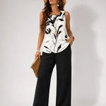 White sleeveless top with black abstract print and black wide-leg pants