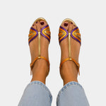 Gold open-toe sandals with multicolored woven straps and buckle ankle strap