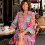 V-neck dress with tiered skirt and colorful geometric print; three-quarter sleeves