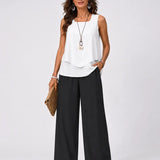 Sleeveless white layered top and black wide-leg pants outfit, full-body view