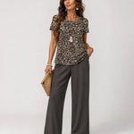 Animal-print short-sleeve top with wide-leg dark gray pants, scoop neckline
