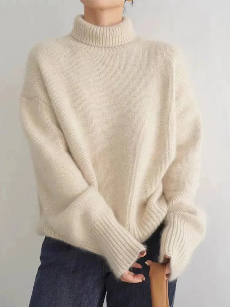 Beige ribbed turtleneck cashmere sweater with dropped shoulders and long sleeves.