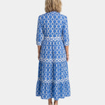 Back view of blue midi tiered shirt dress with link print and three-quarter sleeves