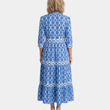 Back view of blue midi tiered shirt dress with link print and three-quarter sleeves