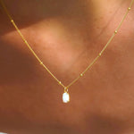 Gold opal pendant necklace with small oval white opal charm