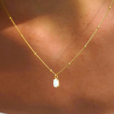 Gold opal pendant necklace with small oval white opal charm