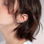 Silver star ear cuff with three sparkling cross stars, worn on ear