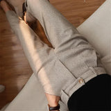 Light gray herringbone trousers with front crease and round button