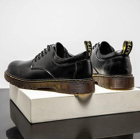 Black lace-up shoes with yellow pull tabs and tan platform sole