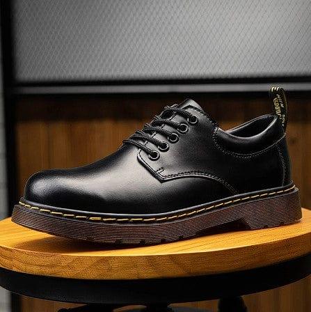 Black oxford-style lace-up shoes with eyelets and tan ridged sole