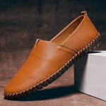 Tan leather slip-on espadrilles with jute sole, stitched trim, and mesh-like edge