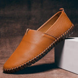 Tan leather slip-on espadrilles with jute sole, stitched trim, and mesh-like edge
