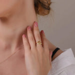 Gold embrace ring with curved open design, worn on finger