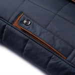 Navy jacket sleeve close-up with brown trim button placket and quilted stitching