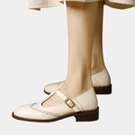 Beige women's classic strap shoes with buckle T-strap and low block heel.