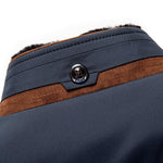 Close-up of navy jacket collar with brown band and round button detail