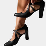 Black heeled slingback pumps with thin ankle tie straps and pointed toe