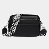 Black leather-look crossbody bag with silver hardware and zigzag patterned strap