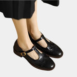 Black women's classic strap shoes with buckle T-strap and low block heel.