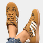 Leopard-print orthopedic sneakers with tan laces, white stripes, gum sole