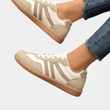 Off-white orthopedic sneakers with tan gum sole and vertical side stripes