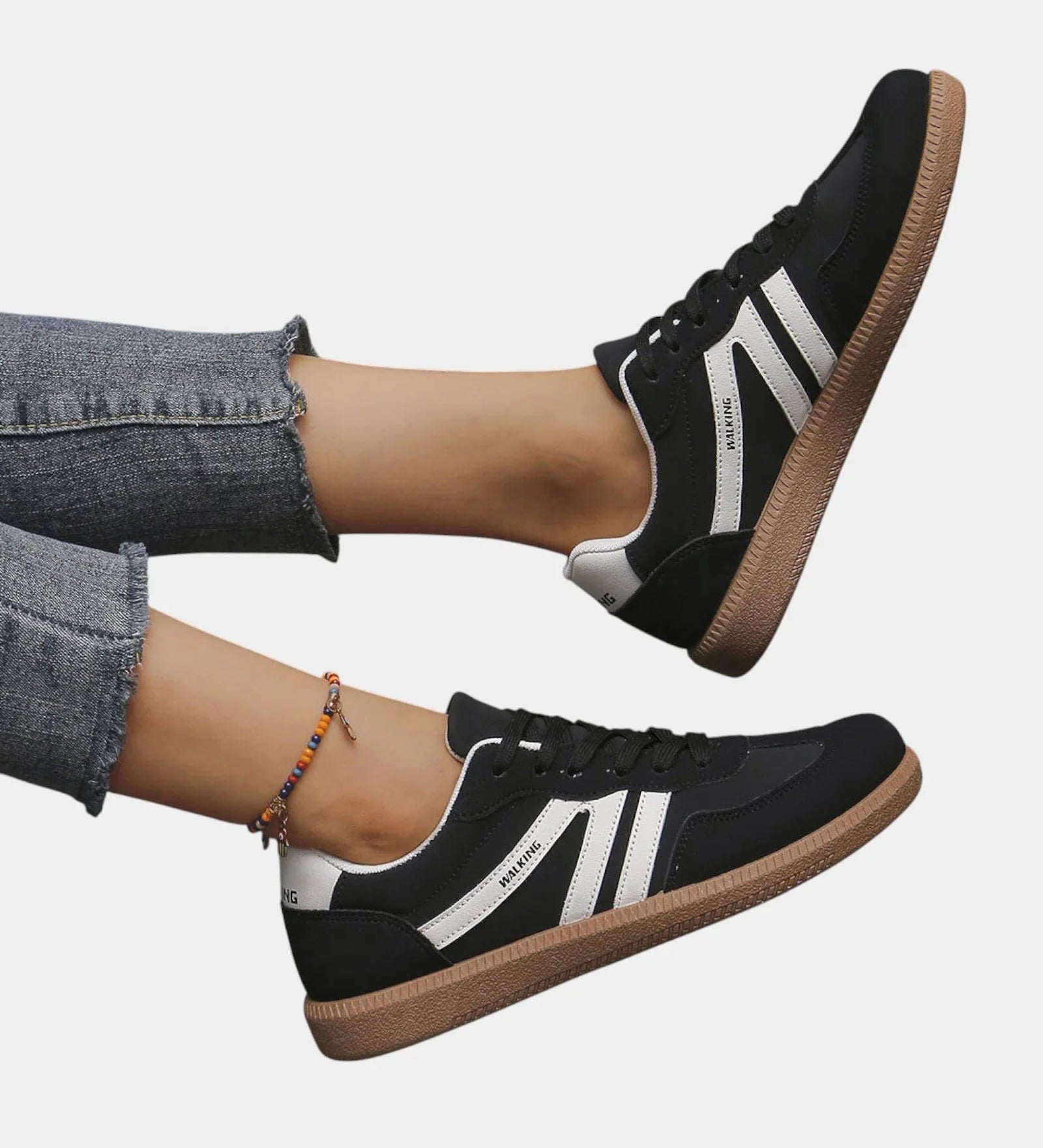 Black orthopedic sneakers with white side stripes and tan gum sole