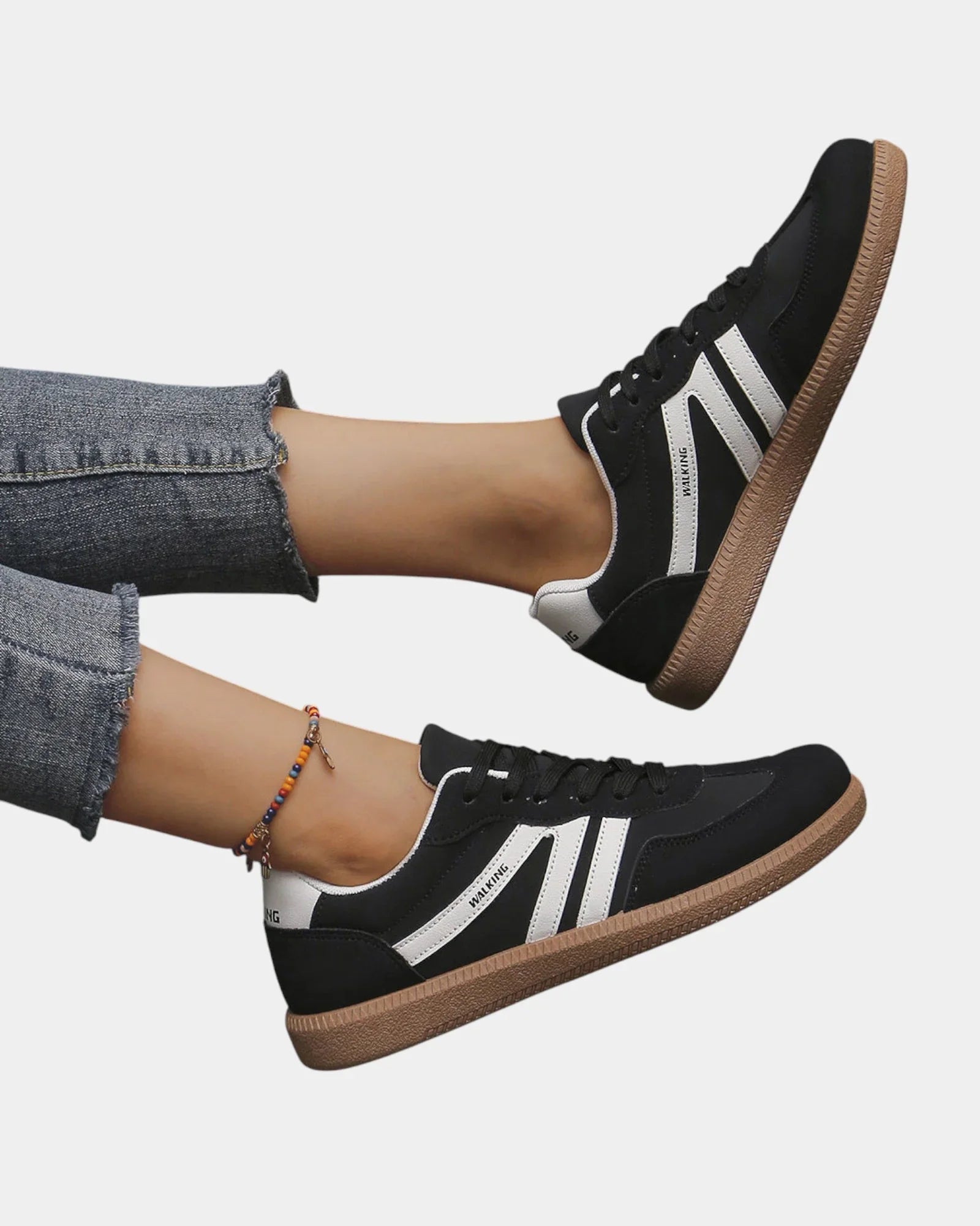 Black orthopedic sneakers with white side stripes and tan gum sole