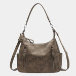Textured brown shoulder bag with long straps, top handles, and two zip pockets