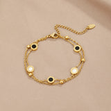 Gold chain bracelet with alternating black and white round stone discs on clasp side