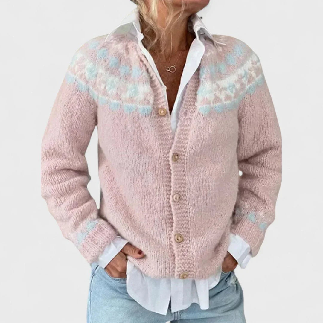 Light pink knit cardigan with scattered blue and pastel motifs, button front