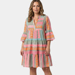 Printed midi dress with V-neck and tiered skirt, pink and orange geometric print on greenish fabric