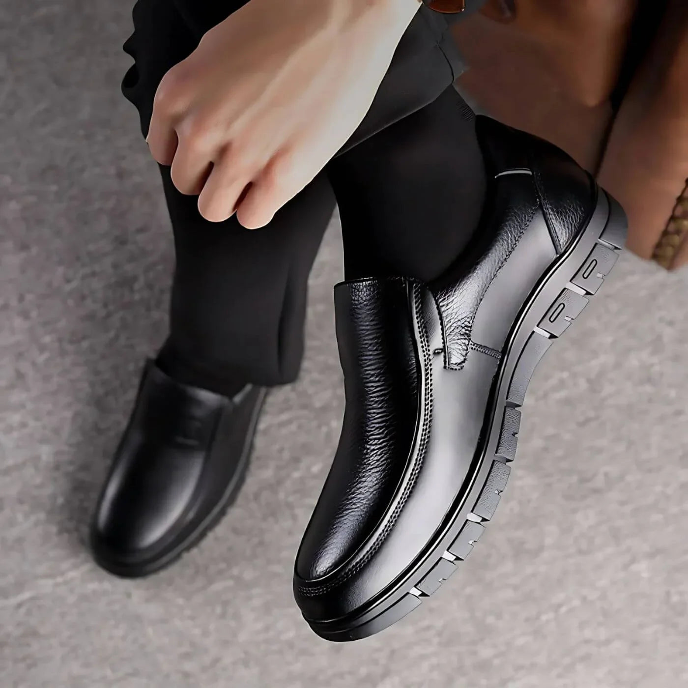 Black leather slip-on shoe with elastic gore, rounded toe, and tread sole