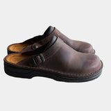 Dark brown leather-look clog with adjustable buckle strap and black sole.