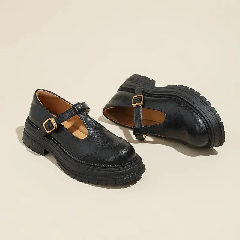 Black leather Mary Jane shoes with T-strap, gold buckle, and chunky outsole